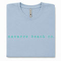 Navarre Beach Co. tee with crisp turquoise lettering on a light blue shirt