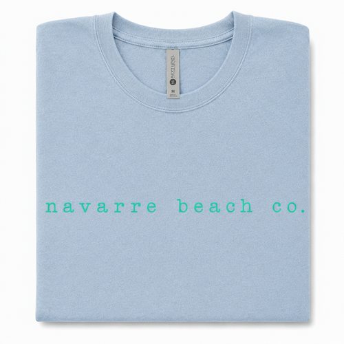 Navarre Beach Co. tee with crisp turquoise lettering on a light blue shirt